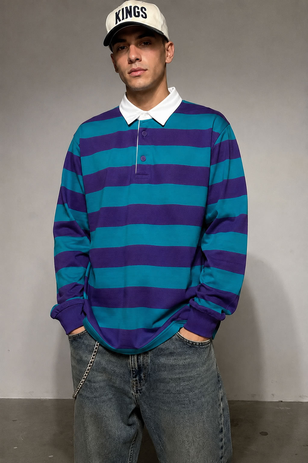 new purple and teal striped men's rugby shirt worn by model with jeans and a kings snapback hat