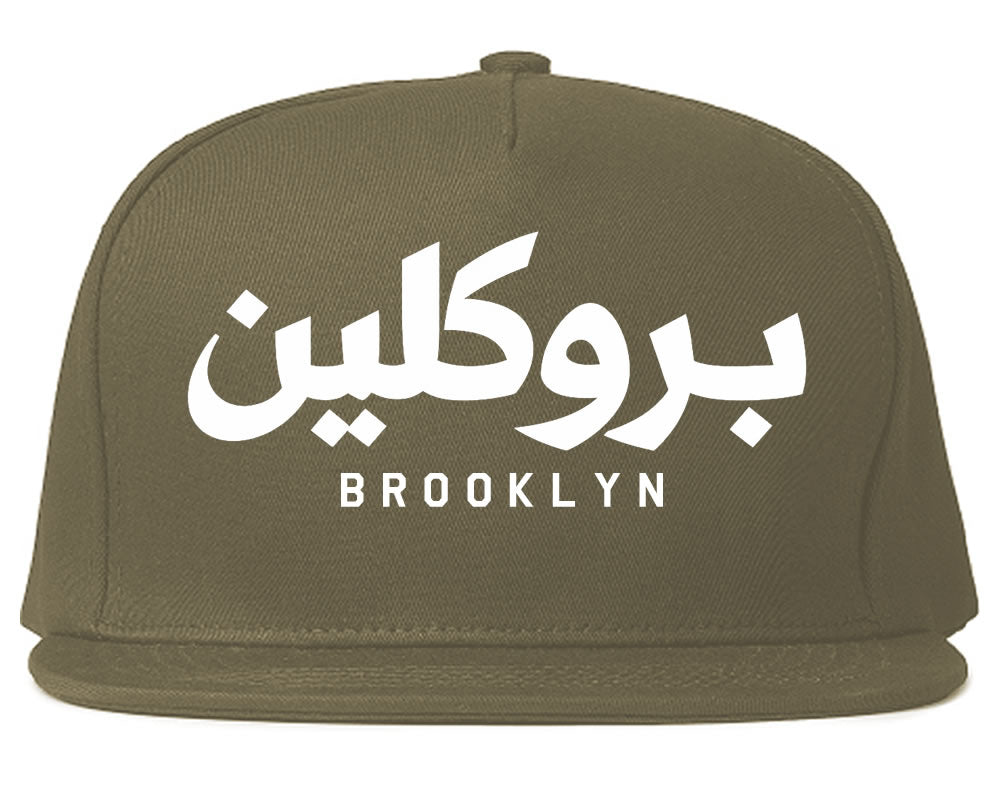 Grey snapback hat with Arabic text and 'Brooklyn' printed below on a white background
