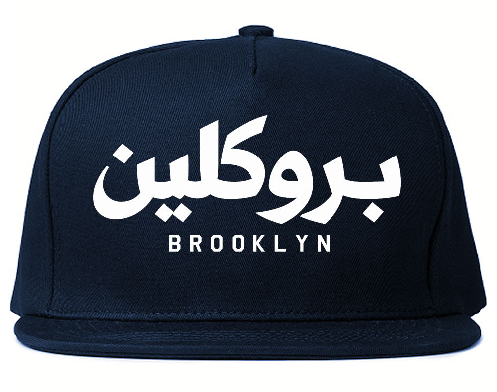 Navy blue snapback hat with white Arabic text and 'Brooklyn' printed below on a white background