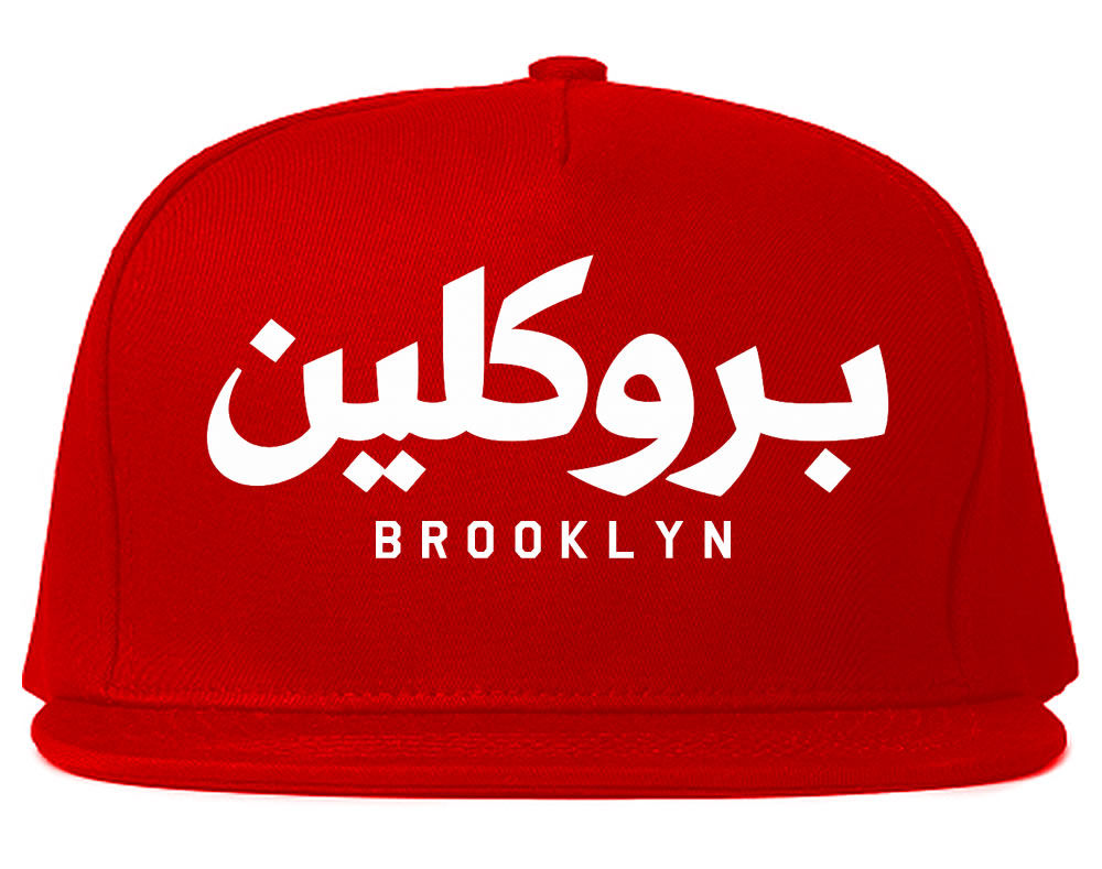 Red snapback hat with white Arabic text and 'Brooklyn' printed below on a white background