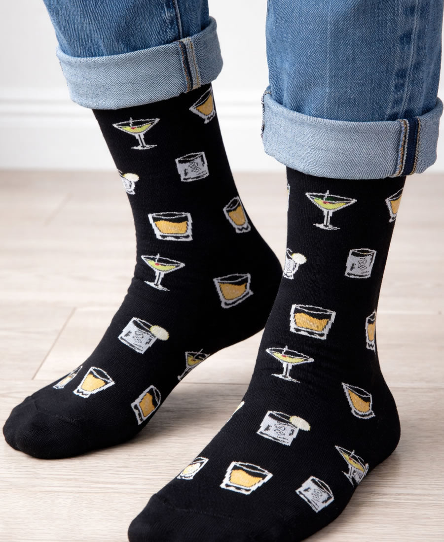 Black socks with cocktail-themed design worn by a person in jeans.