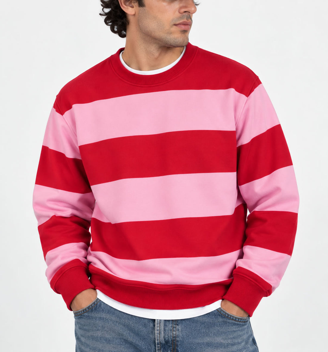 A man wearing a red and pink striped crewneck sweatshirt with blue jeans, shown from the chest down against a plain white background.