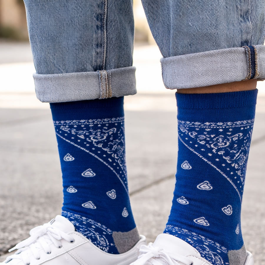 Blue paisley badana patterned socks worn with white sneakers and rolled-up jeans